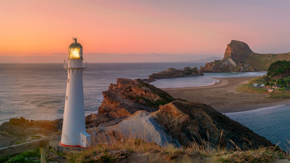 a light house sitting on top of a cliff next to the ocean