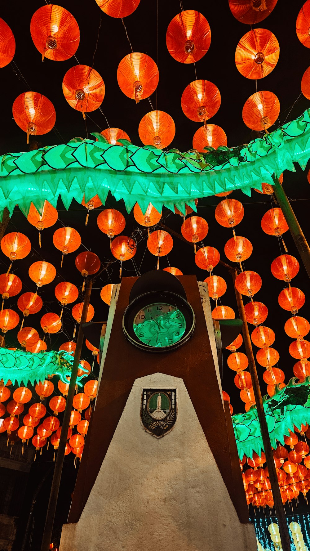 a room filled with lots of orange and green lanterns