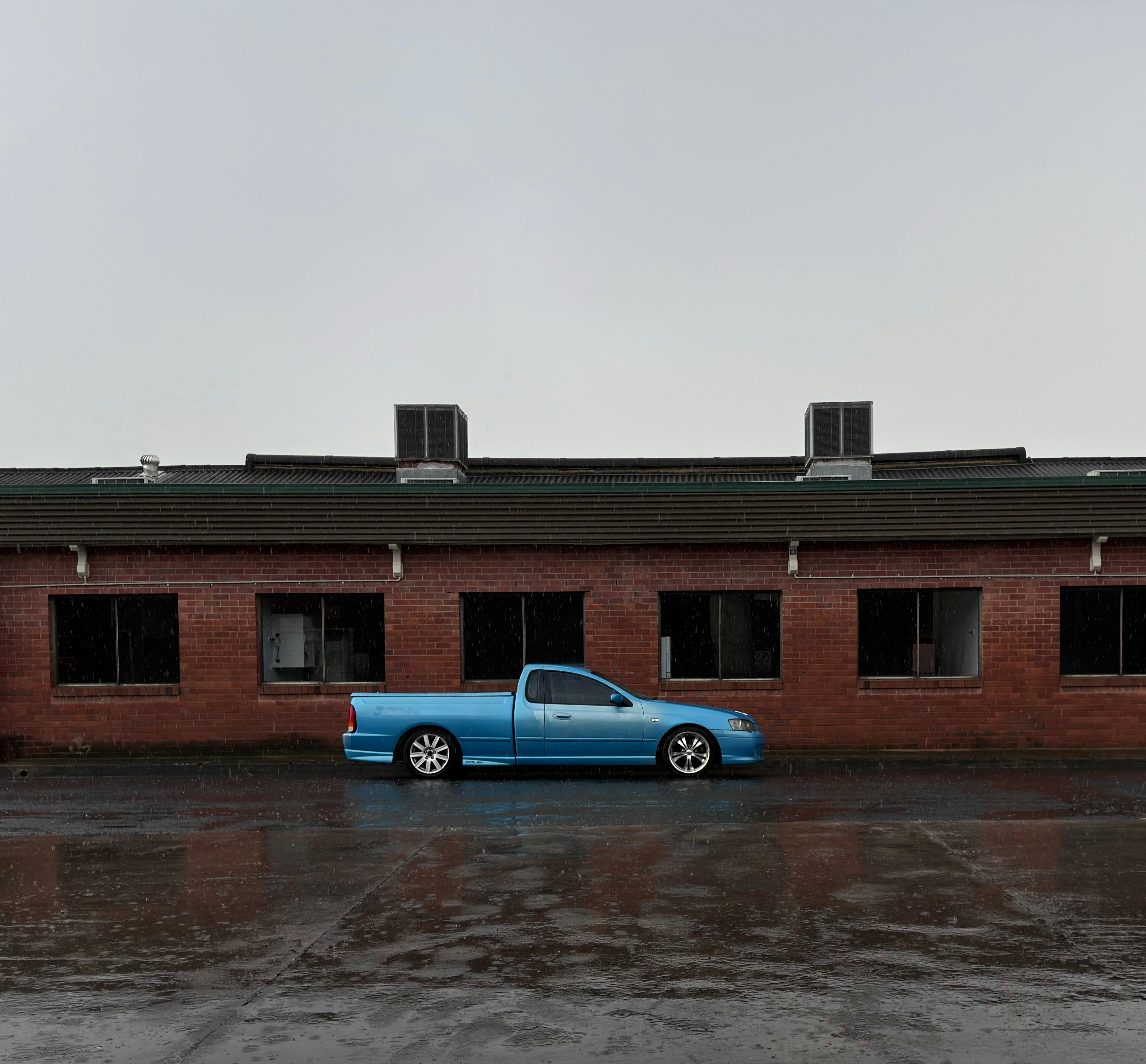 a blue truck parked in front of a brick building