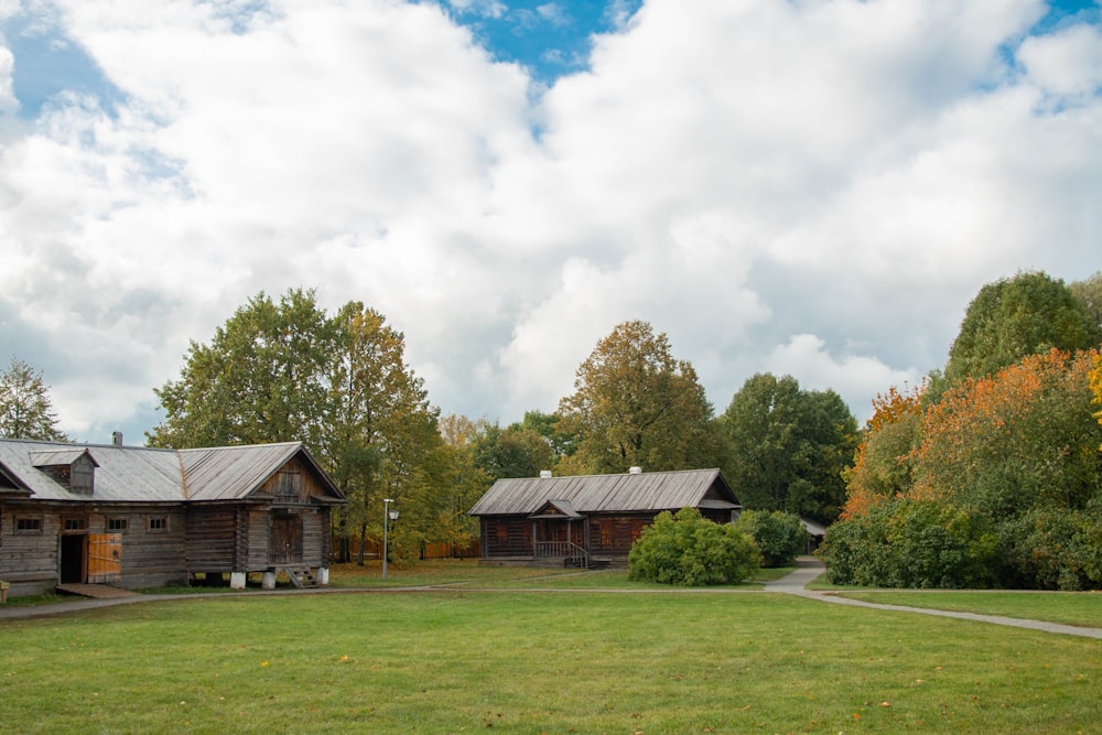 a couple of cabins sitting in the middle of a lush green field