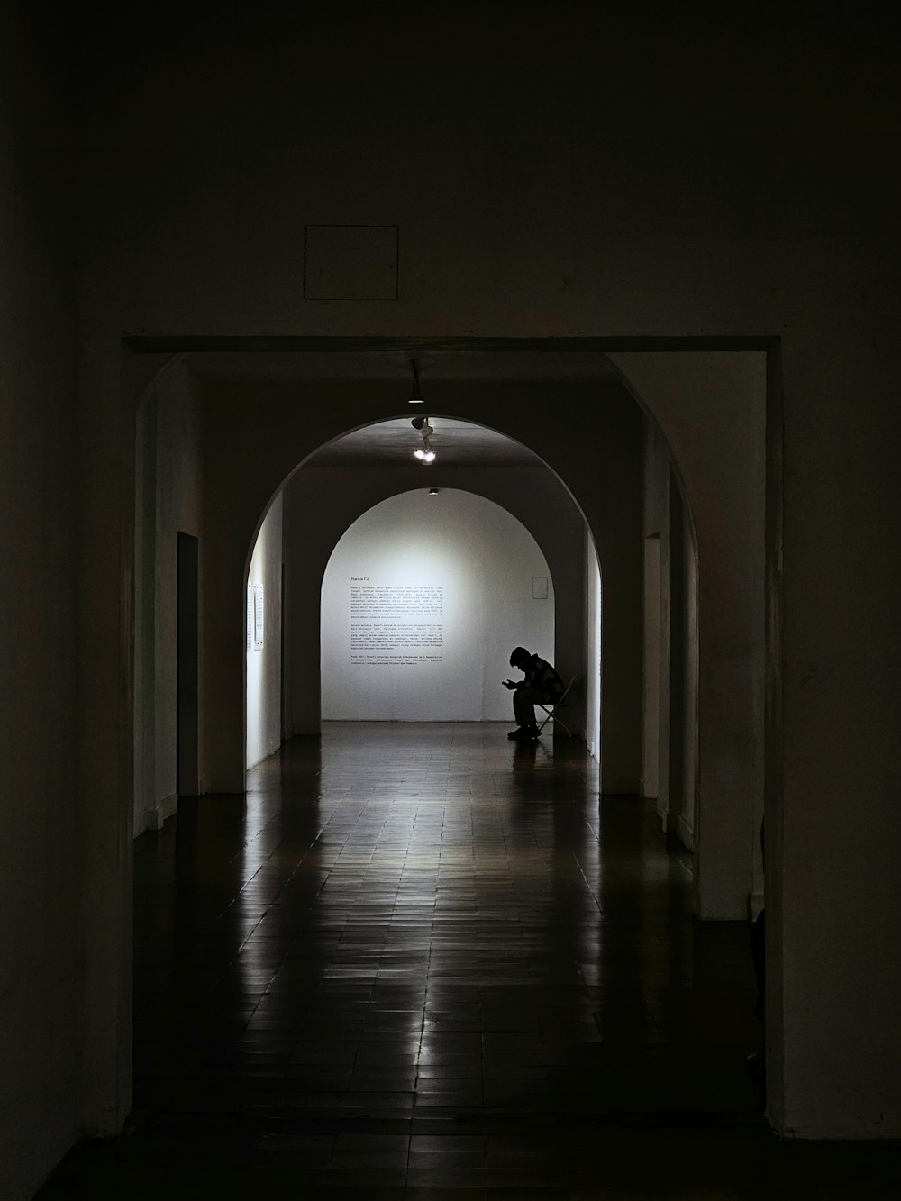 a person sitting on a bench in a dark tunnel