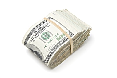 a stack of one hundred dollar bills tied with a string