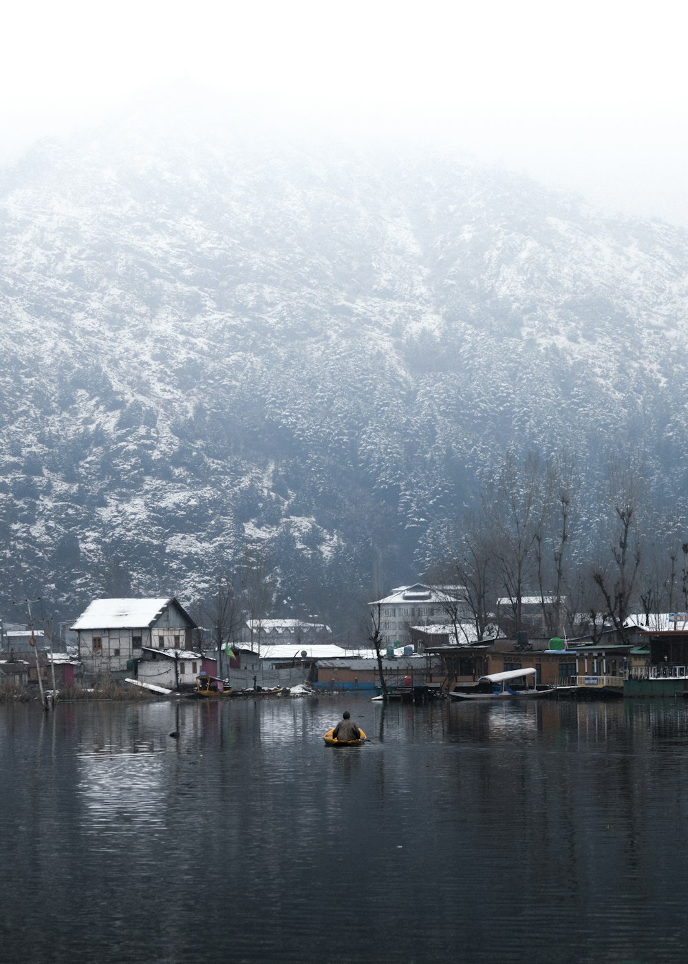 a body of water surrounded by mountains and houses