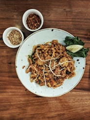 a white plate topped with noodles and meat