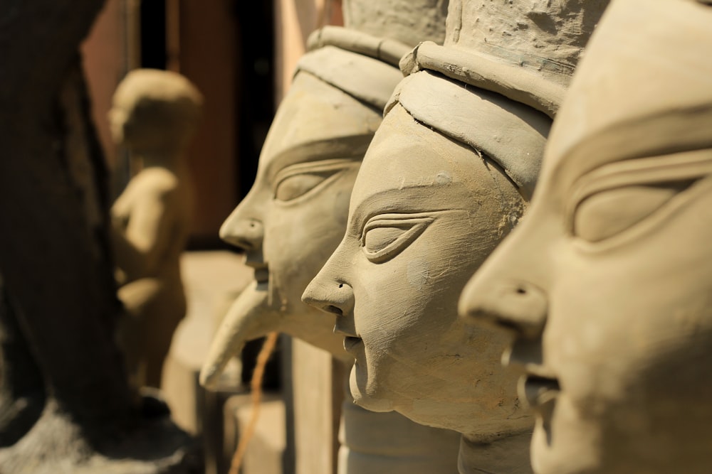 a close up of a group of clay faces