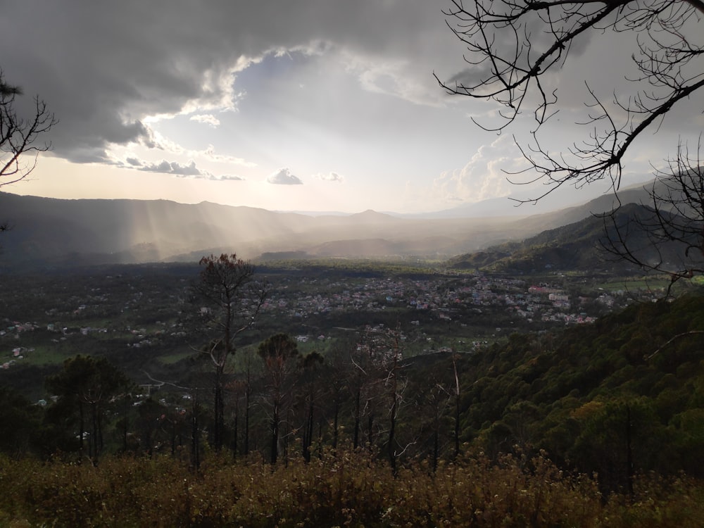 the sun shines through the clouds over a valley