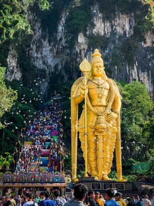 a large statue of a man holding a spear in front of a crowd of people