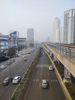 a city street filled with lots of traffic next to tall buildings