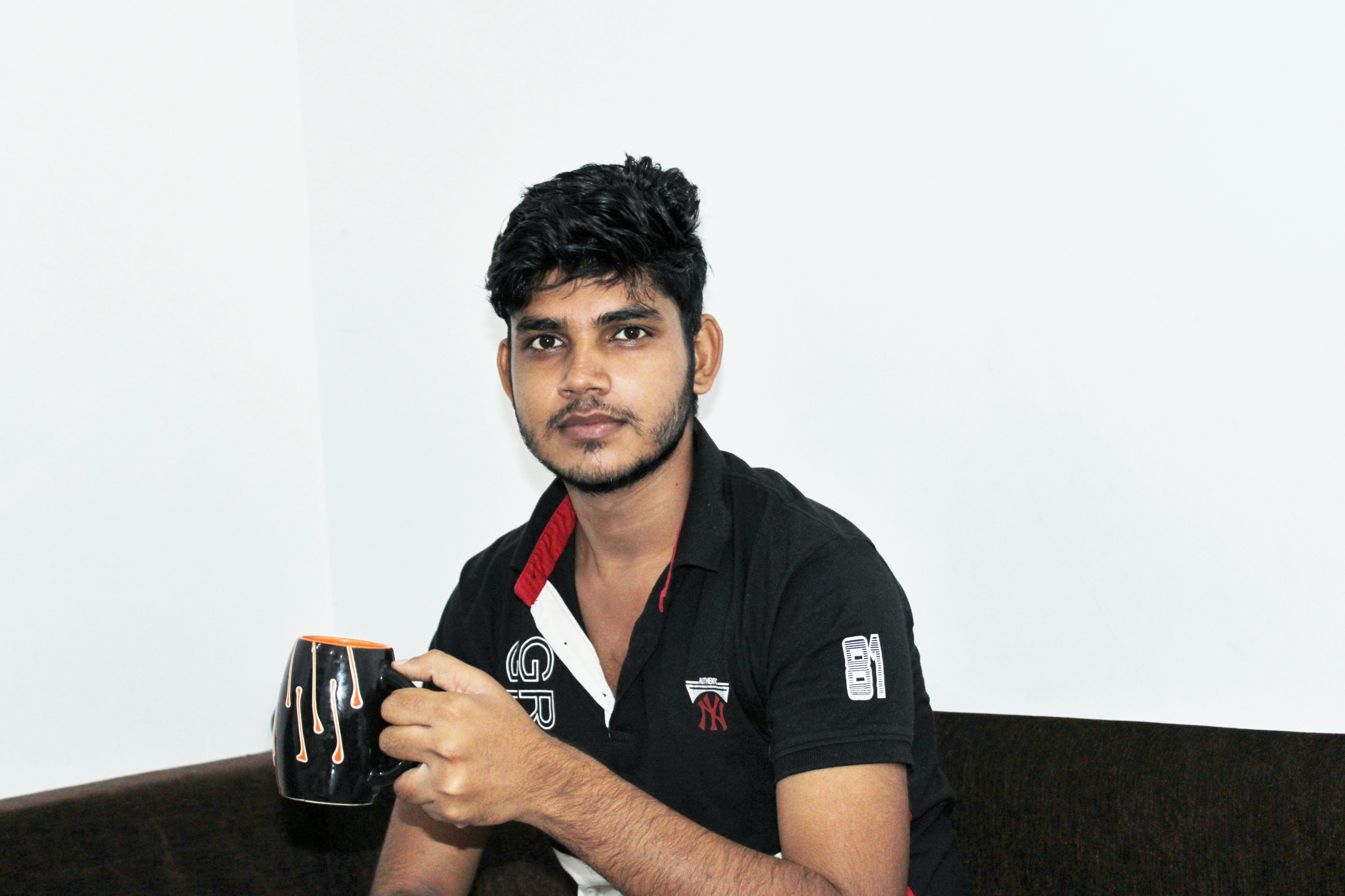 a man sitting on a couch holding a cup