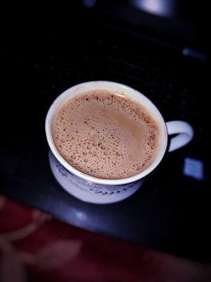 a cup of hot chocolate sitting on top of a stove