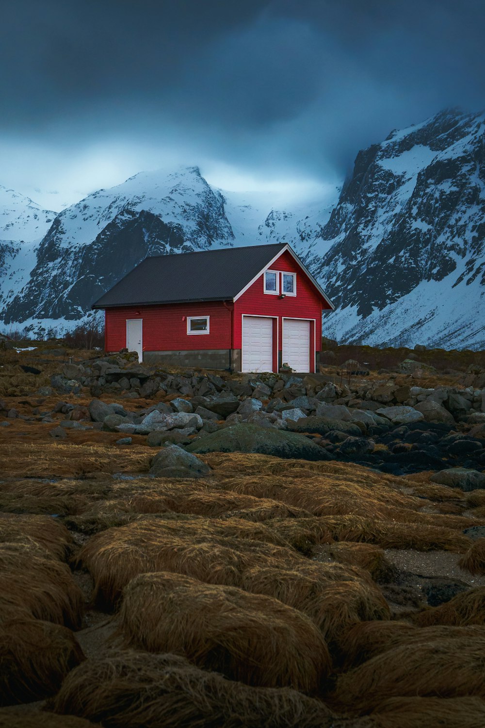 a red house with a mountain in the background