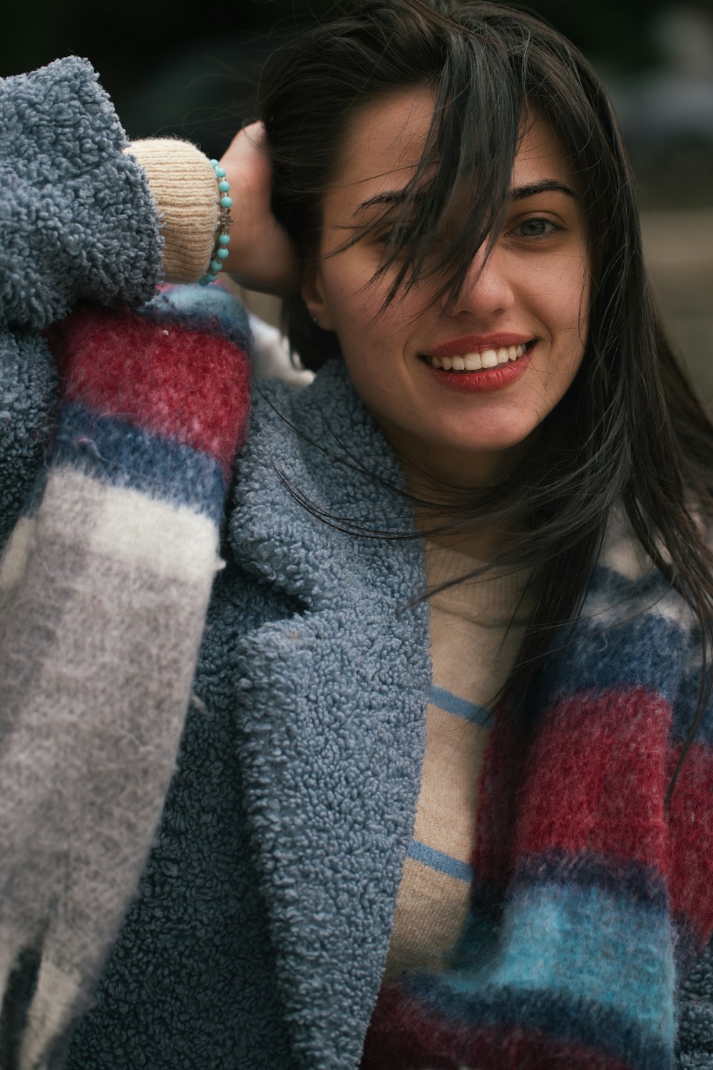 a woman with long hair wearing a striped coat