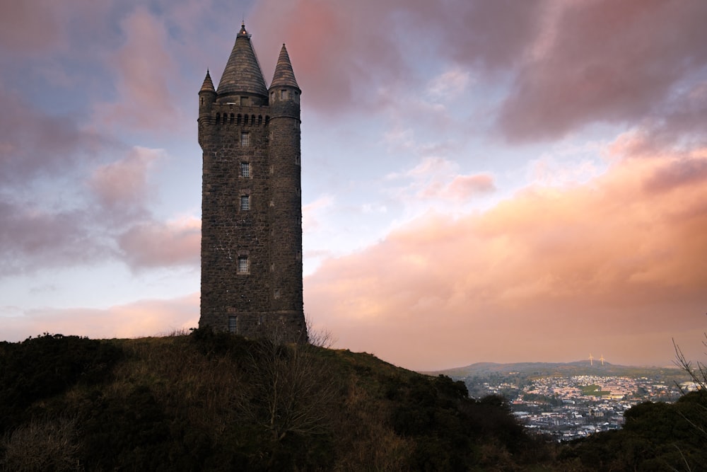 a tall tower sitting on top of a lush green hillside