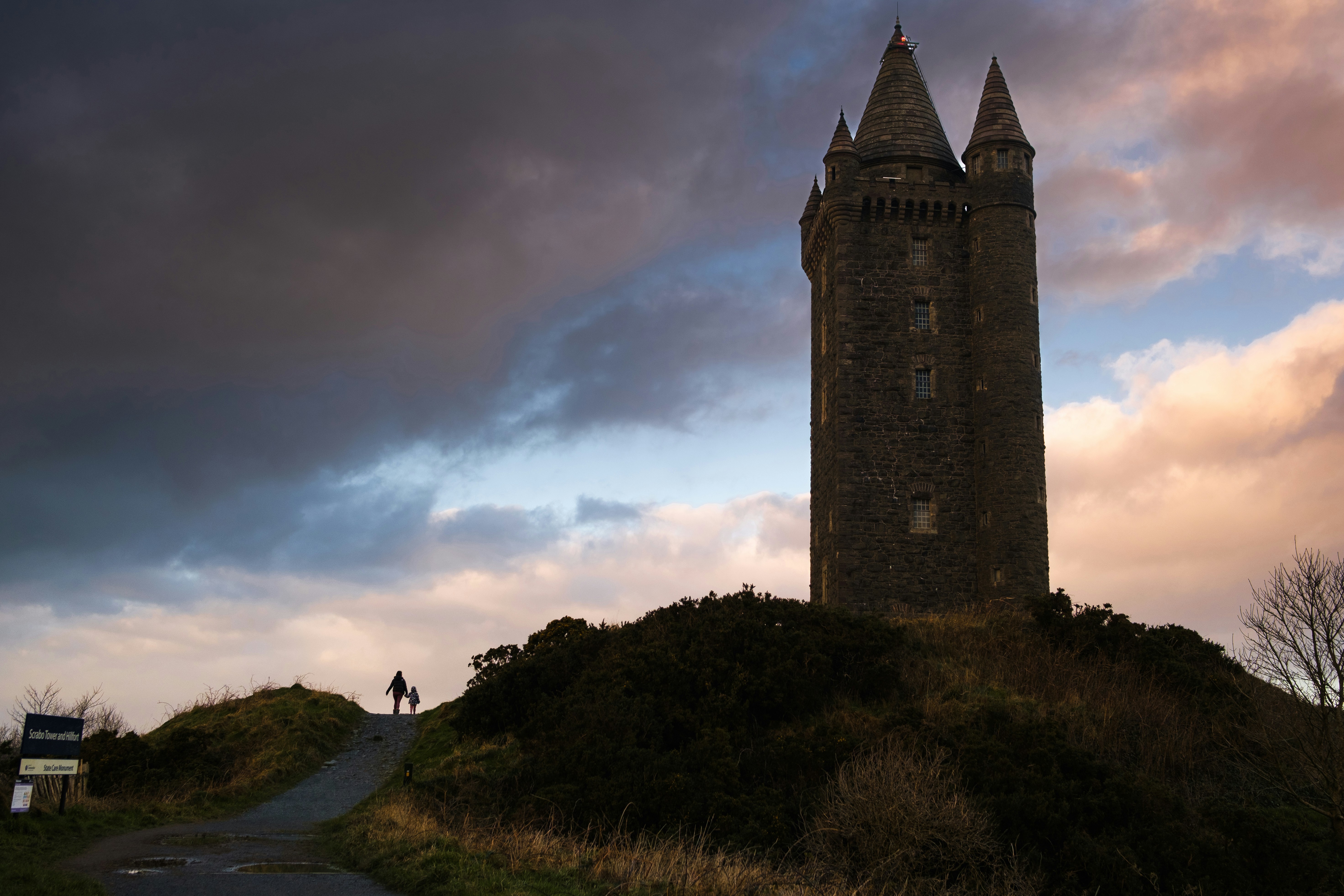 a tall tower sitting on top of a lush green hillside