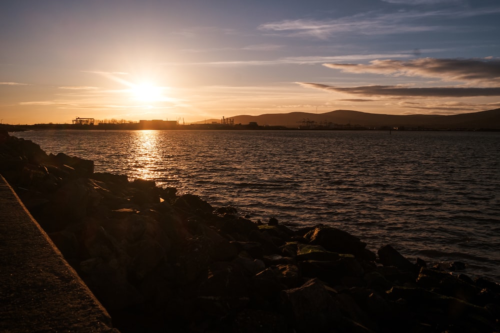 the sun is setting over a body of water