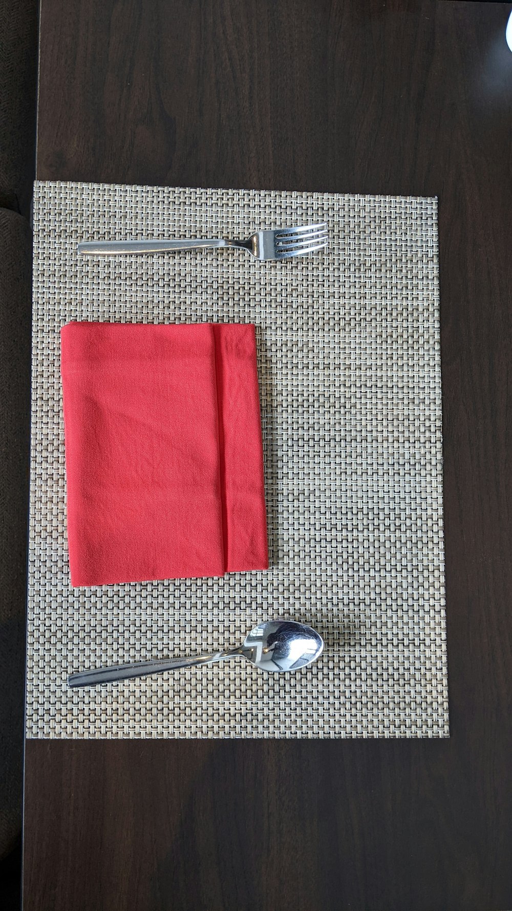 a place setting with a red napkin and silverware