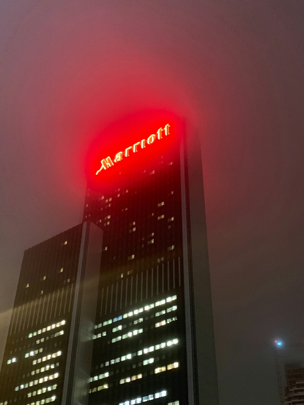 um edifício alto com uma luz vermelha em cima dele