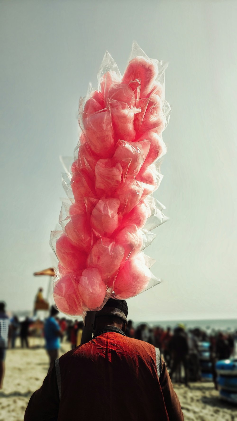 a man on a beach with a pink object on his head