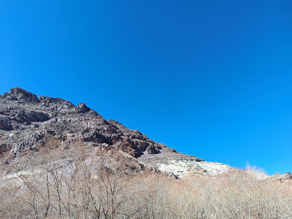 a very tall mountain with a blue sky in the background