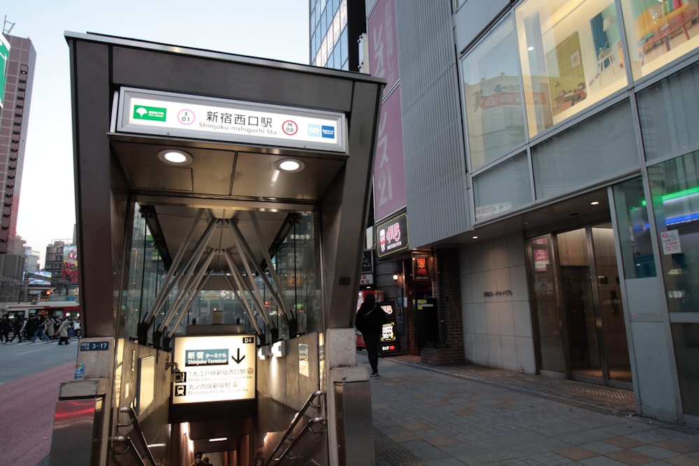 a bus stop on a city street next to tall buildings