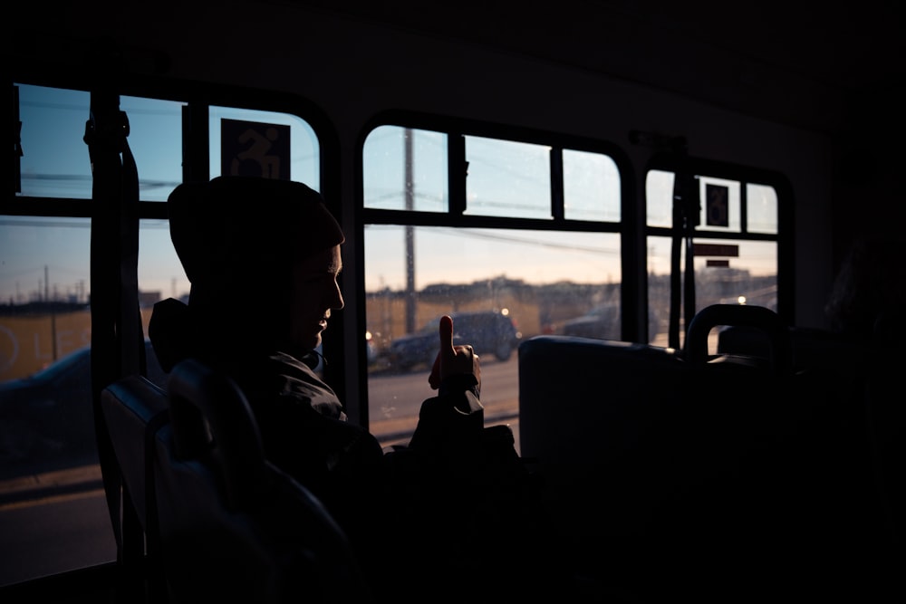 a man sitting in a bus looking out the window