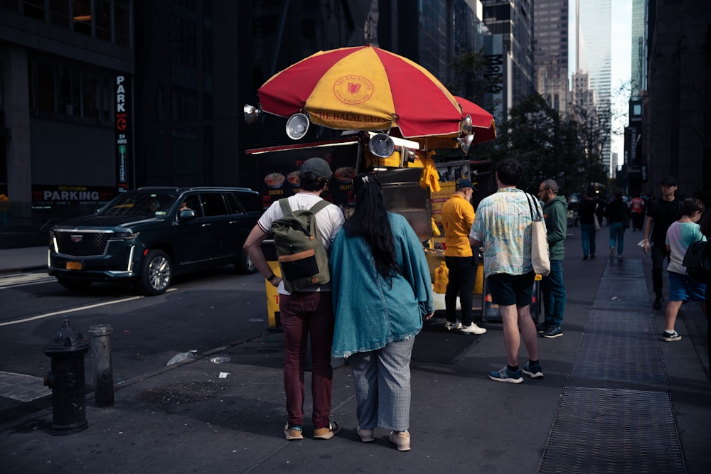 a group of people standing on the side of a road