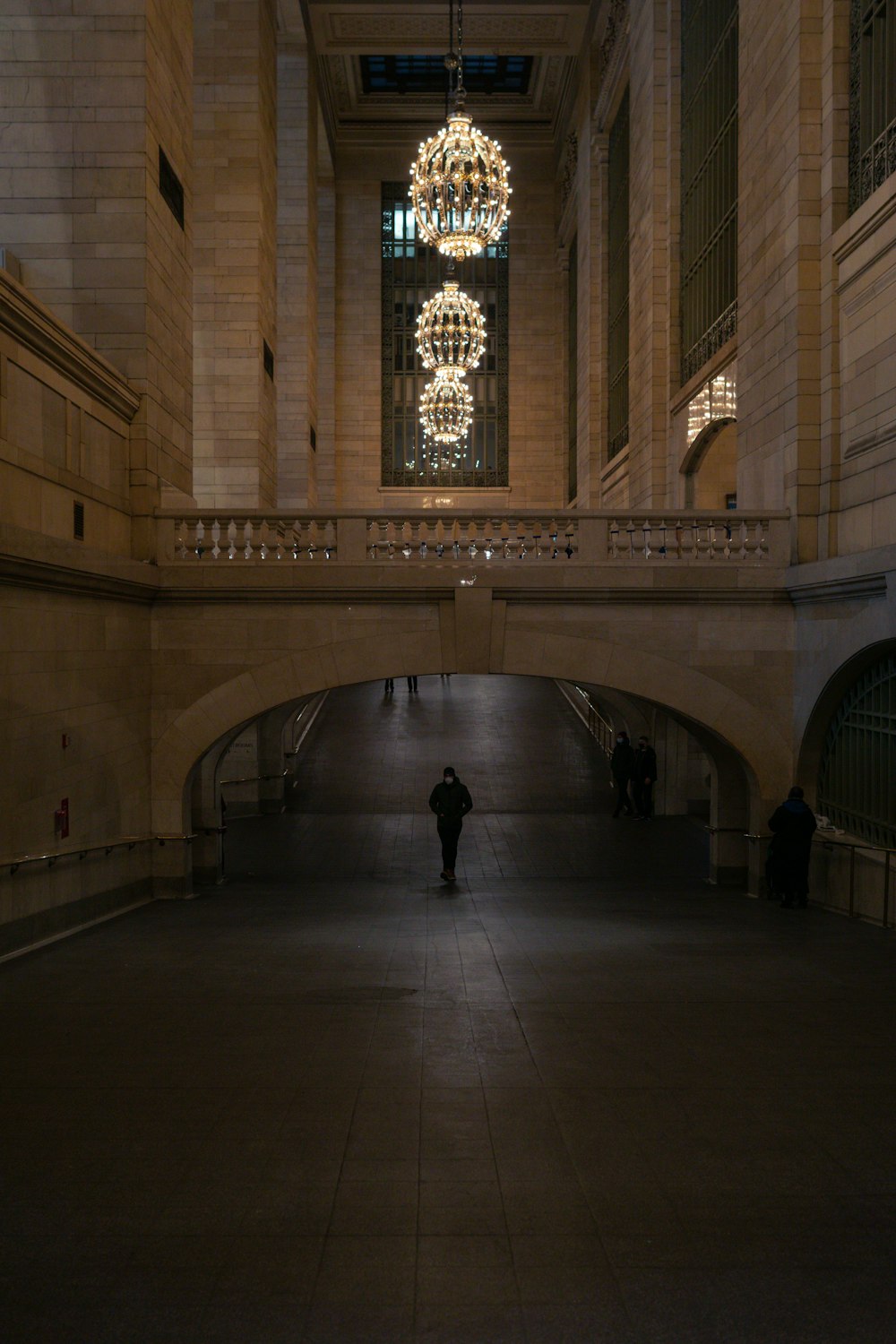 a person standing in a large building with a chandelier