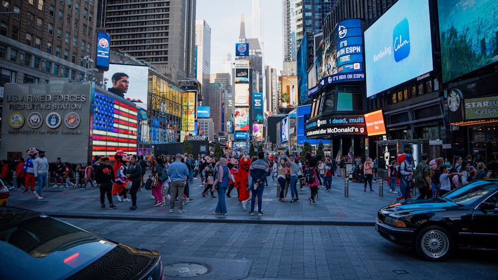 a crowd of people walking down a street next to tall buildings