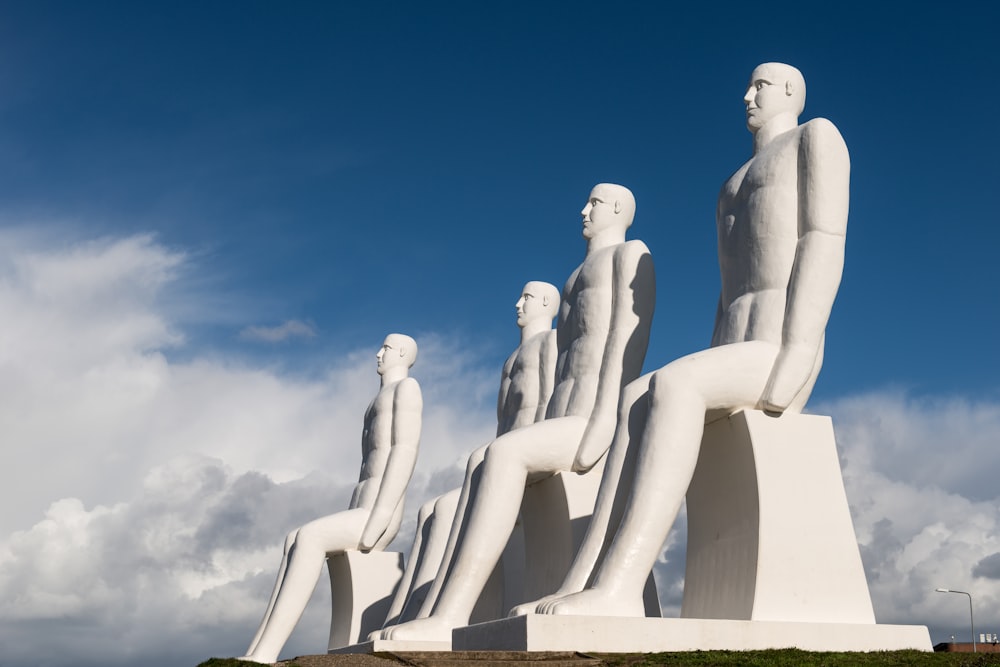 un gruppo di statue di persone sedute in cima a una collina