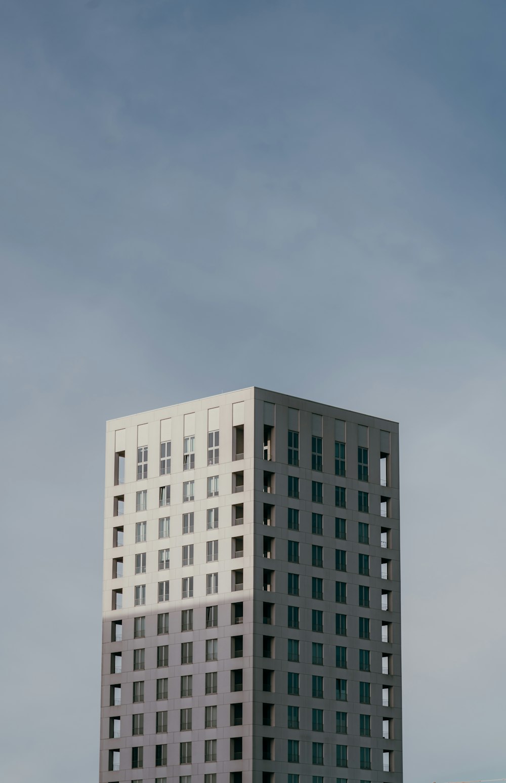 a tall white building sitting next to a parking lot