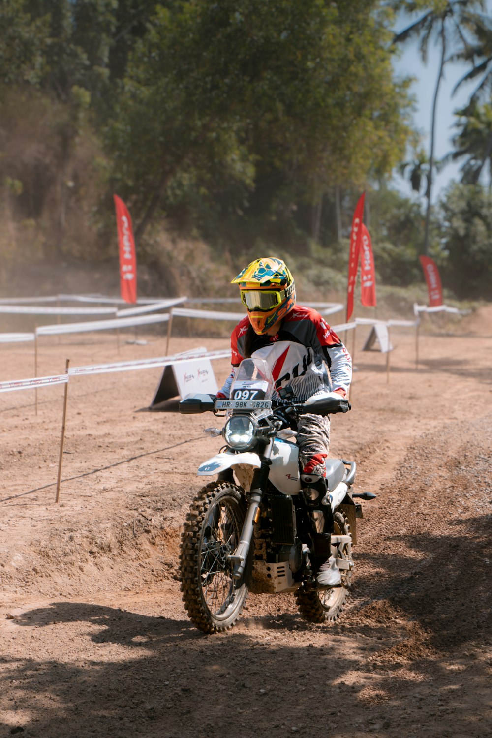 a man riding a dirt bike on a dirt road