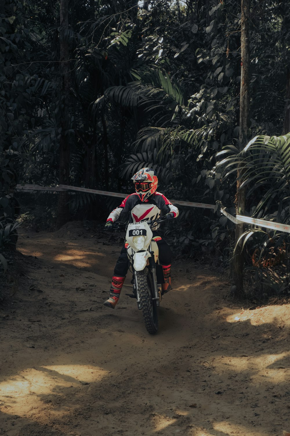 a man riding a dirt bike on a dirt road