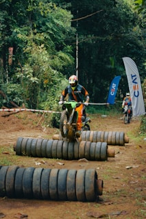 a man riding a dirt bike on top of a pile of tires