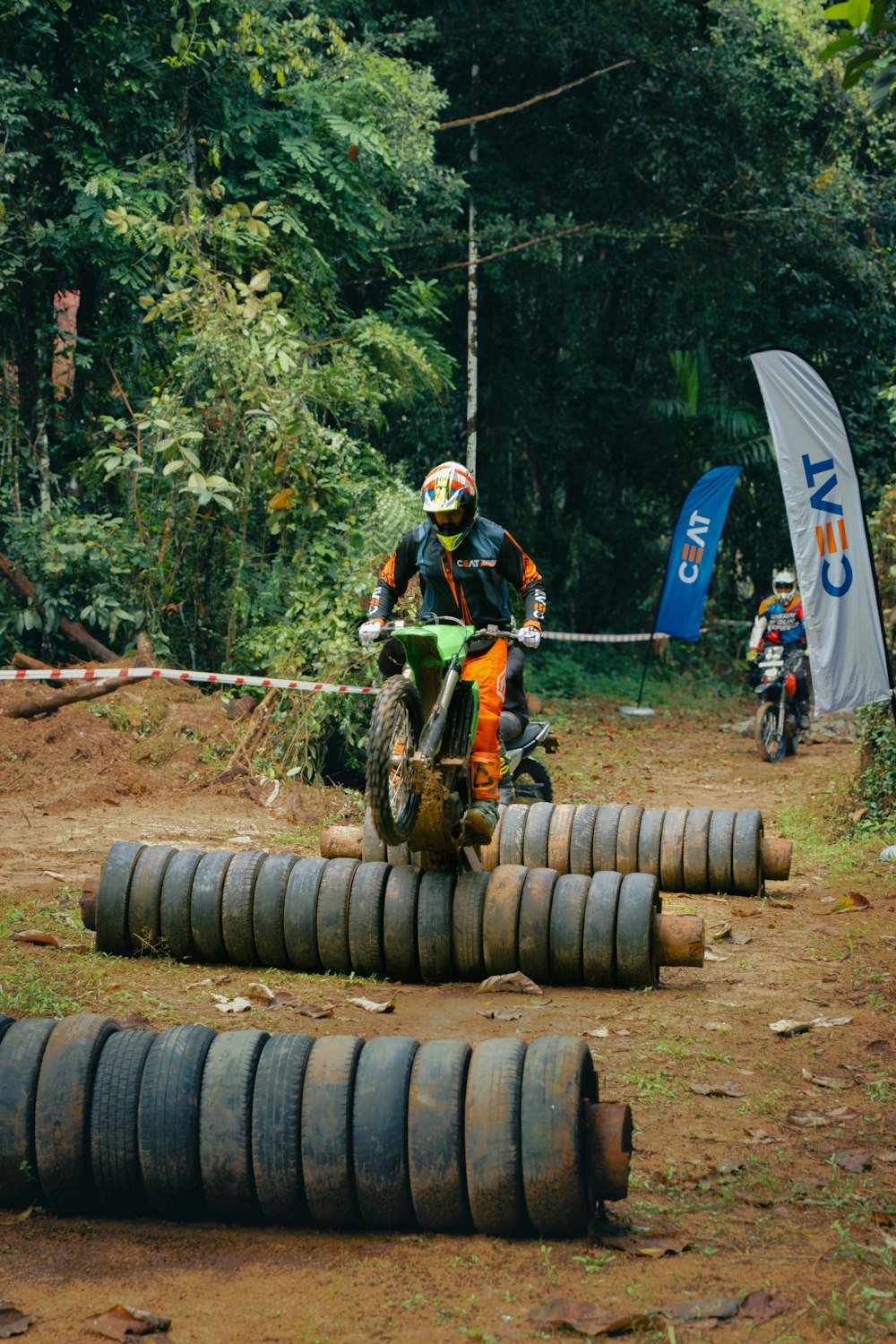 a man riding a dirt bike on top of a pile of tires