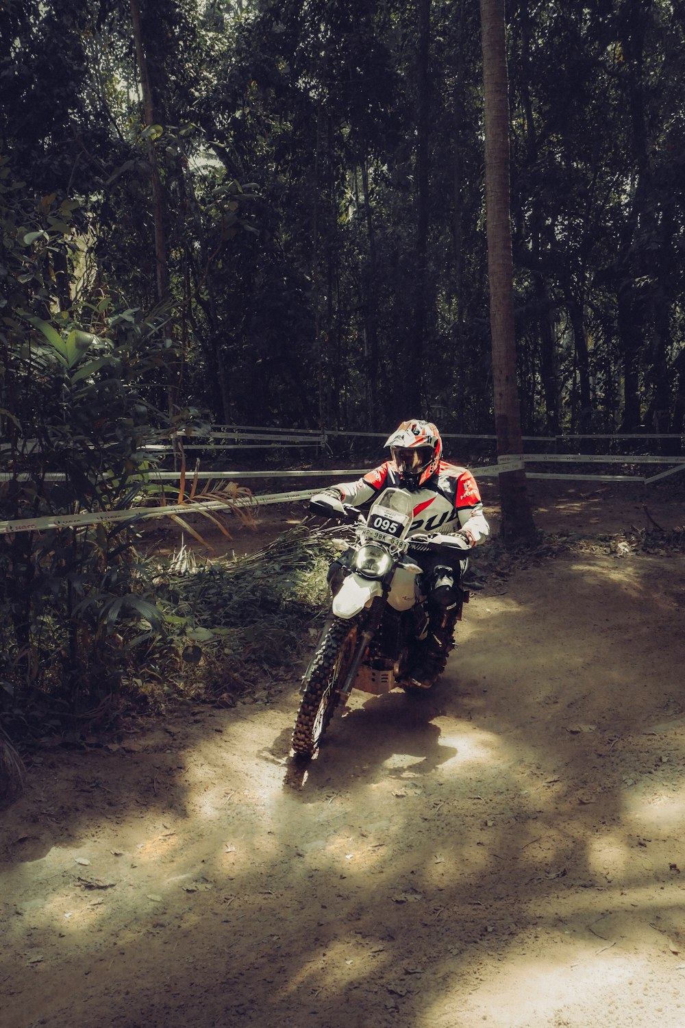 a man riding a dirt bike on a dirt road