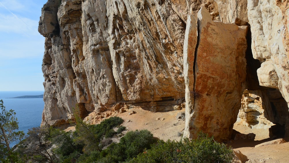 a rocky cliff with a large piece of rock sticking out of it