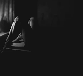 a black and white photo of a woman laying on a bed