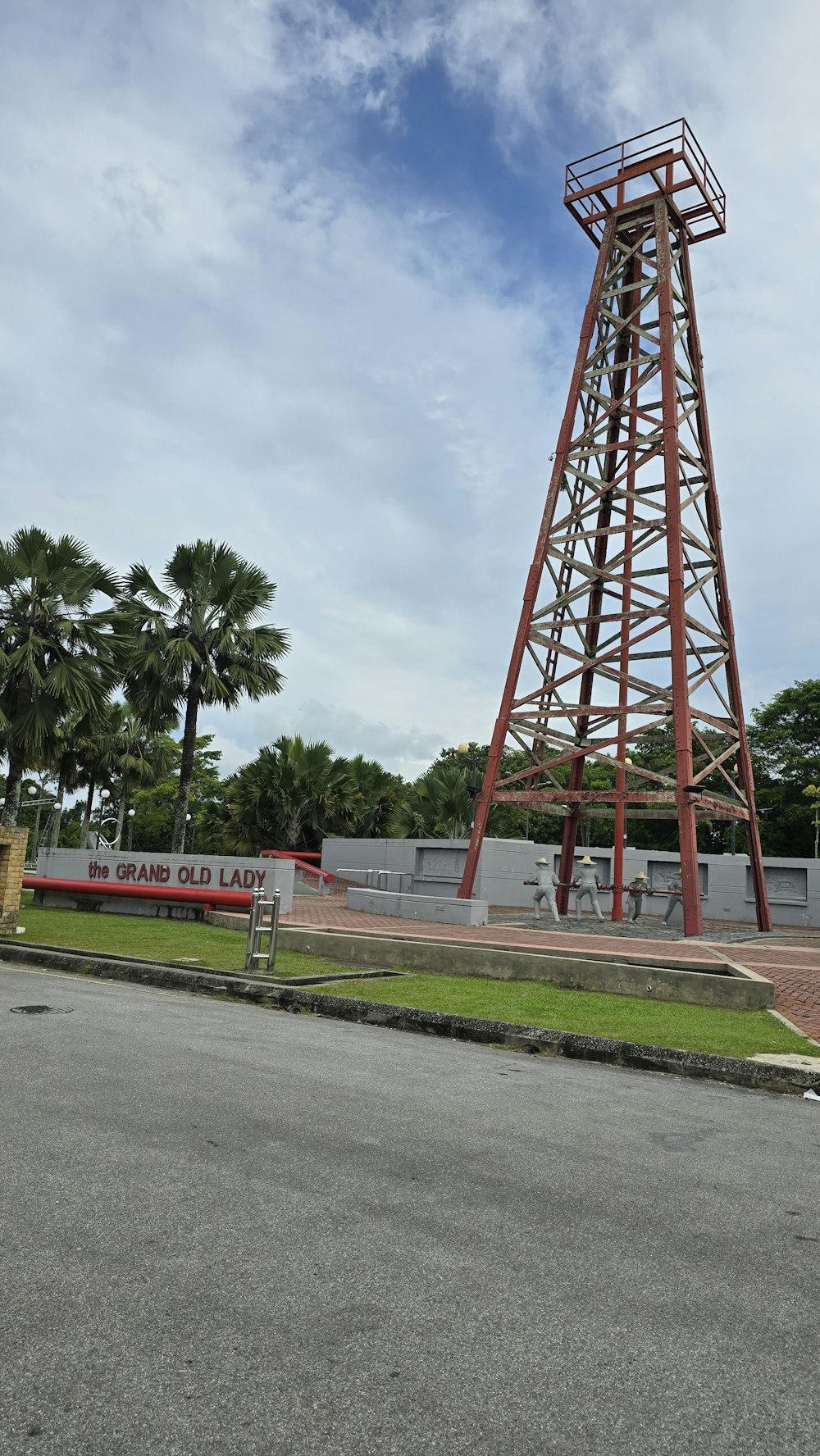 a tall red tower sitting next to a lush green park