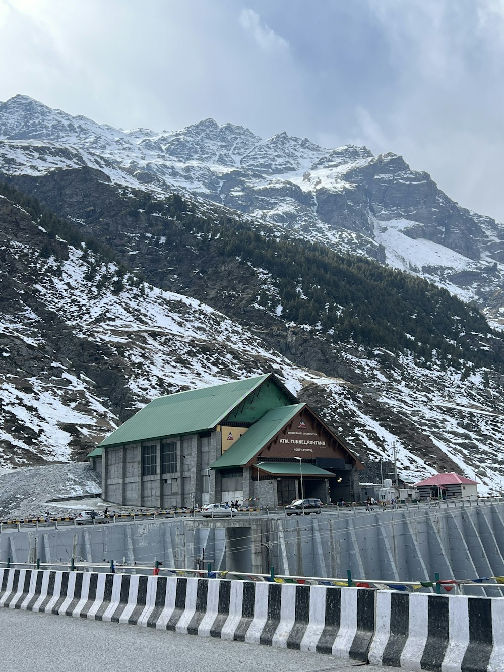 a building on the side of a road with a mountain in the background