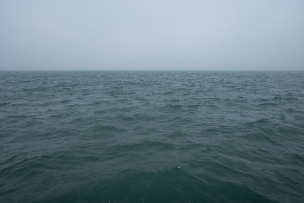 a large body of water with a sky in the background