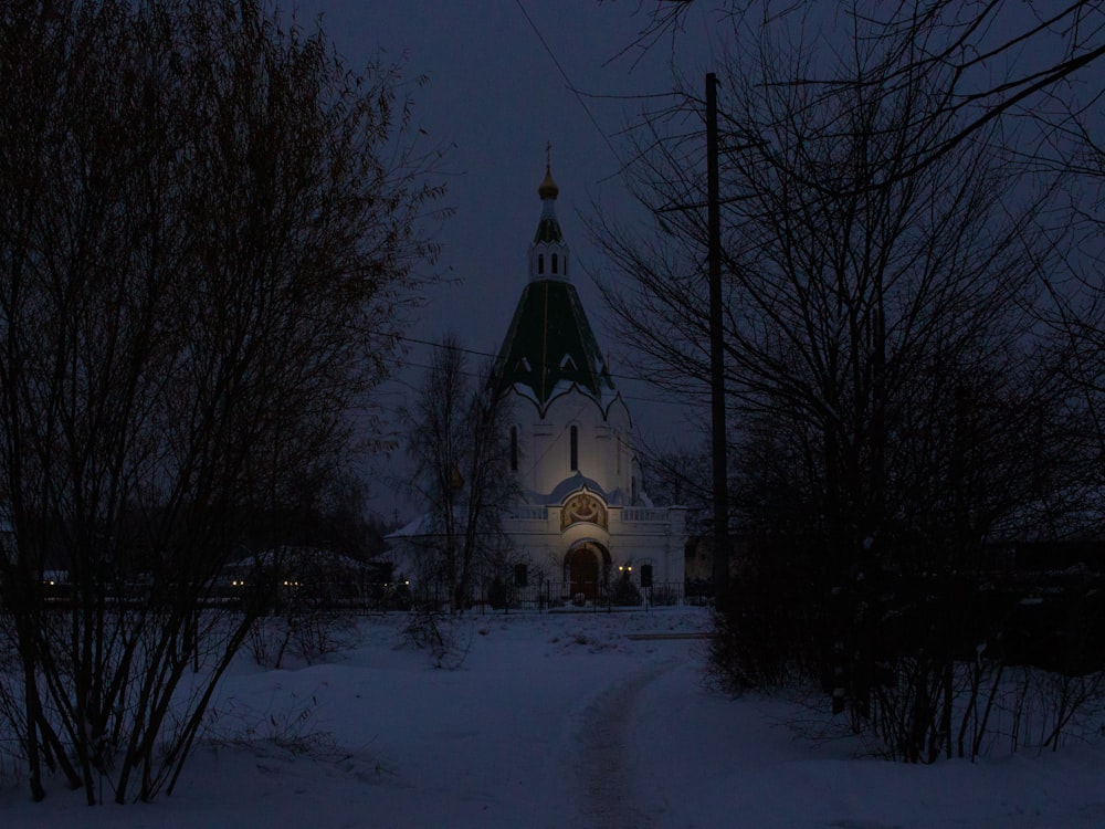 a church lit up at night in the snow