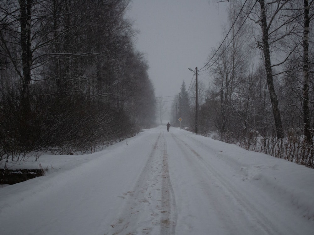 a person walking down a snow covered road