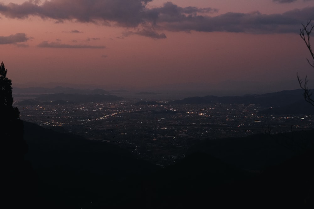 a view of a city from a hill at dusk