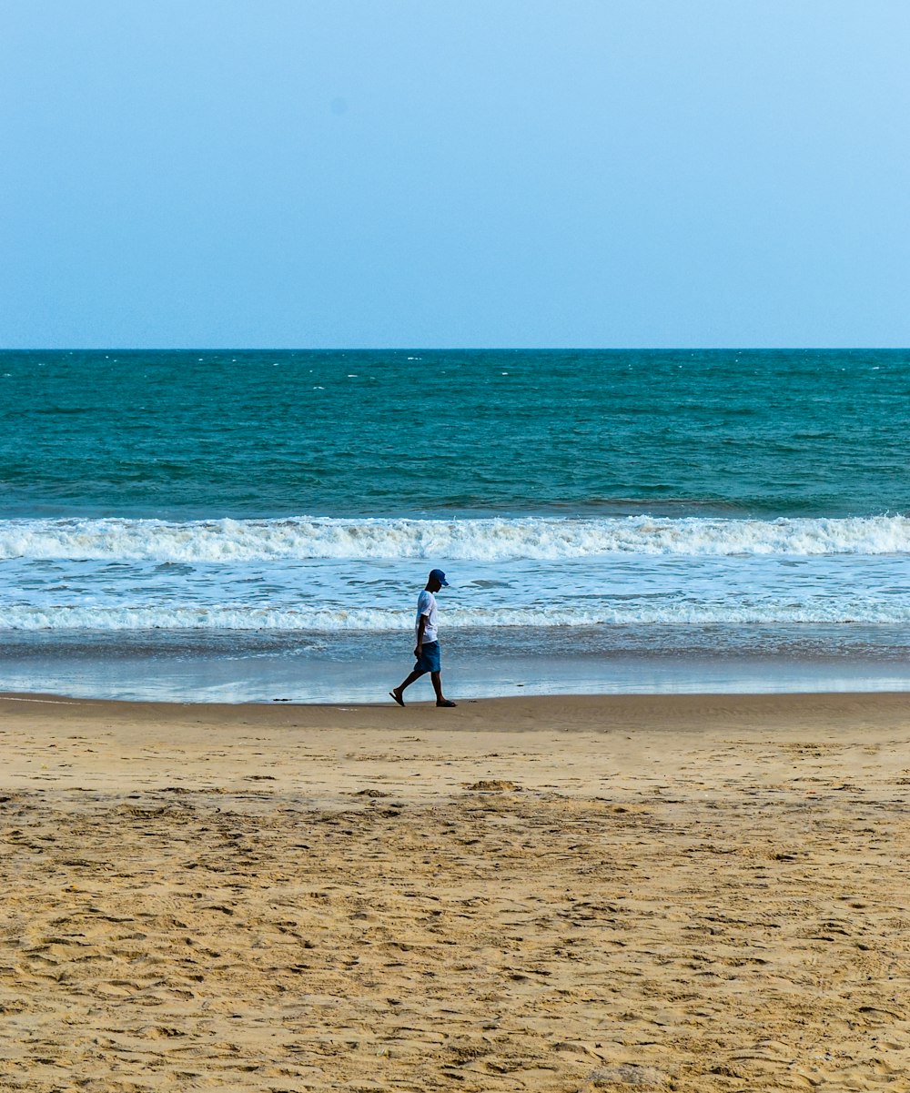 a person running on a beach near the ocean