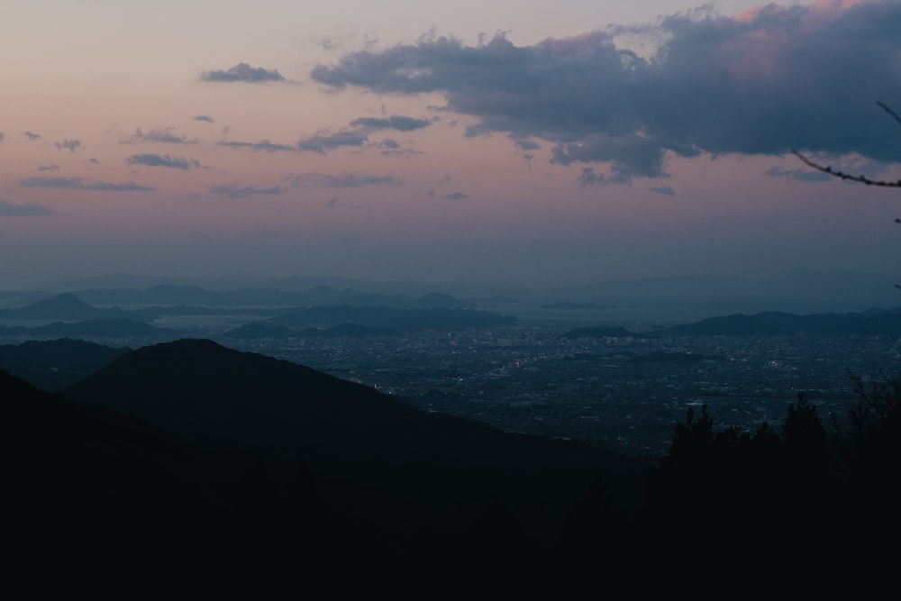 a view of a city and mountains at dusk