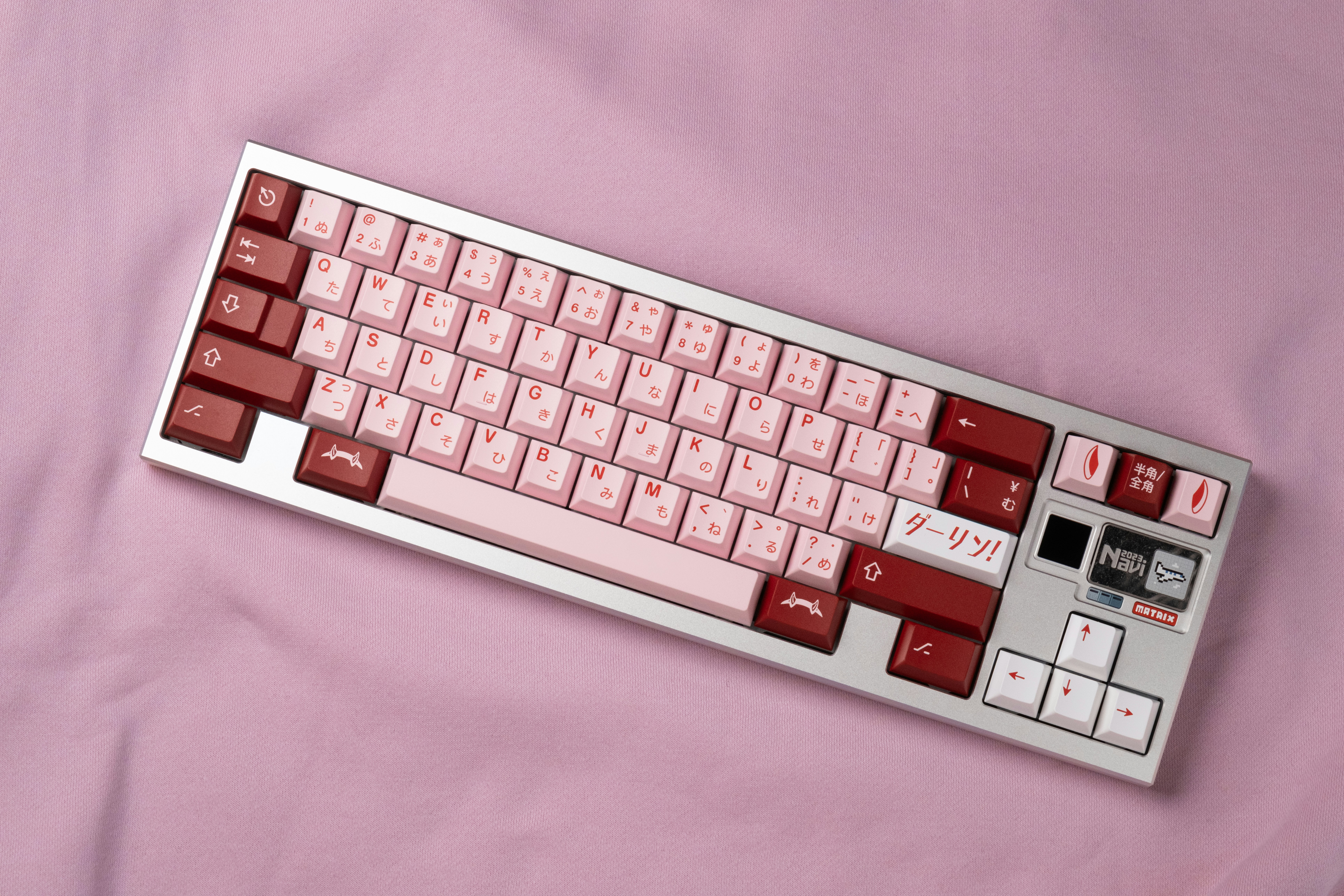 a red and white keyboard sitting on top of a pink sheet