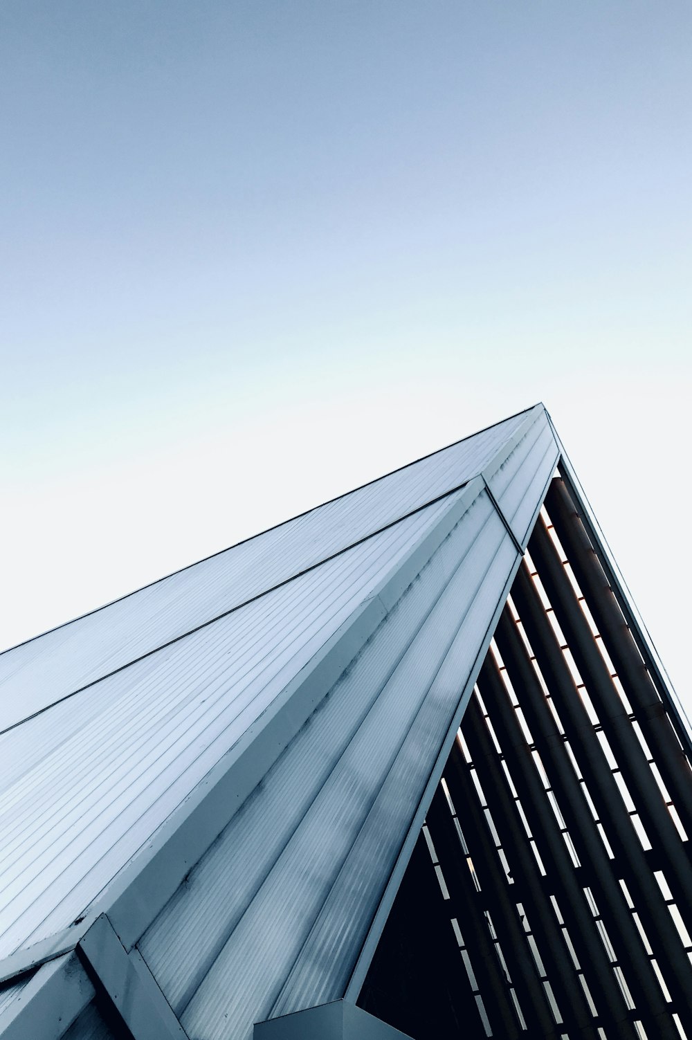 a tall building with a metal roof and a sky background