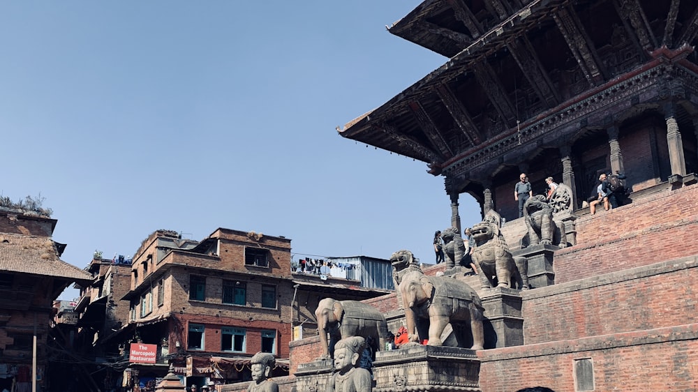 a group of elephants standing on top of a building