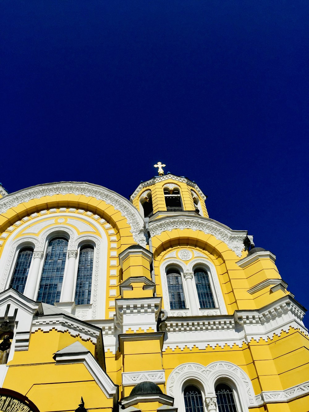 a yellow and white building with a cross on the top