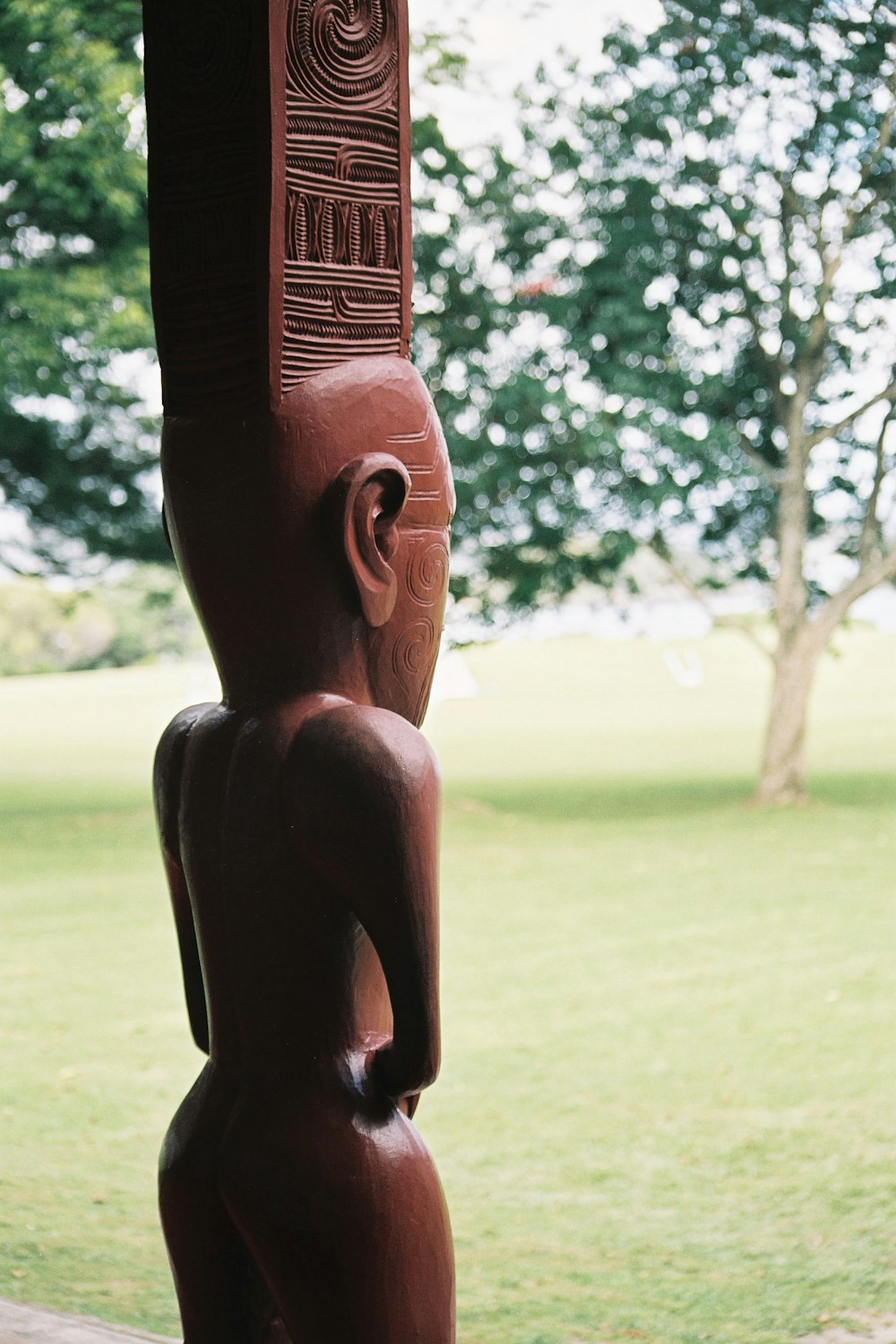 a wooden statue of a person in a park